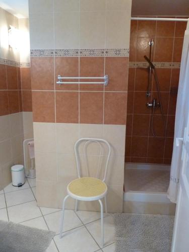 - une chaise dans la salle de bains pourvue d'une douche dans l'établissement La Calvinette, à Pernes-les-Fontaines