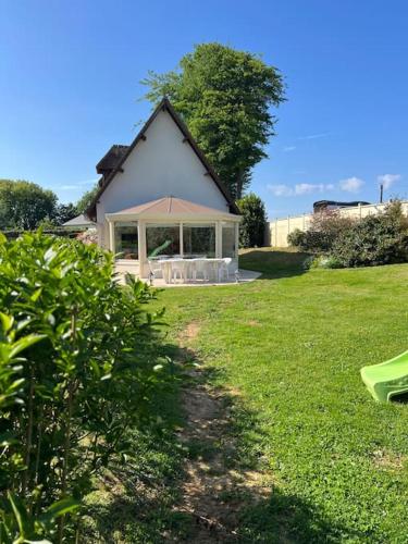 a house with a large window in a yard at Escapade en normandie avec soins bien être in Le Chambray