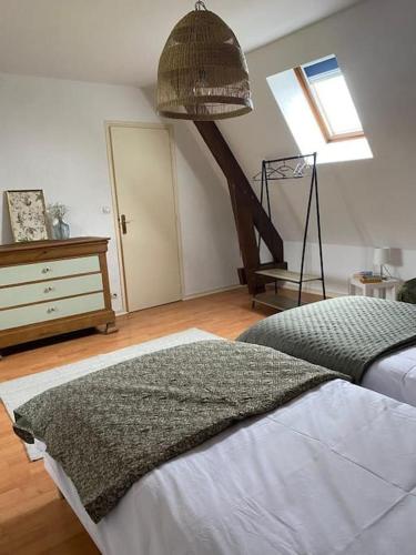 une chambre avec un lit, une commode et une fenêtre dans l'établissement Escapade en normandie avec soins bien être, à Le Chambray