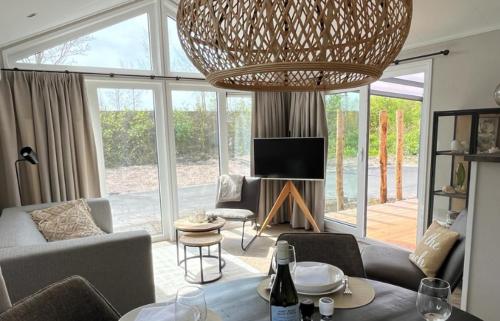 a living room with a couch and a chandelier at Huisje in Dishoek in Koudekerke