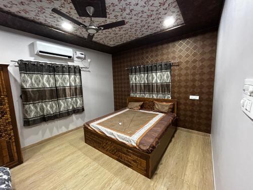 a bedroom with a bed and a ceiling fan at Shantifarmstays in Pali