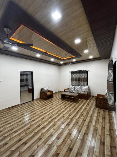 a large room with a wooden floor and a couch at Shantifarmstays in Pali