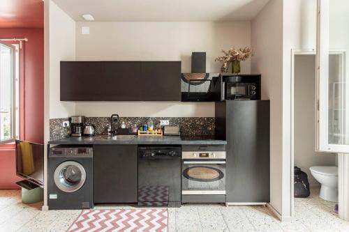 une cuisine avec un lave-linge et un lave-linge dans l'établissement Revest, à Sète