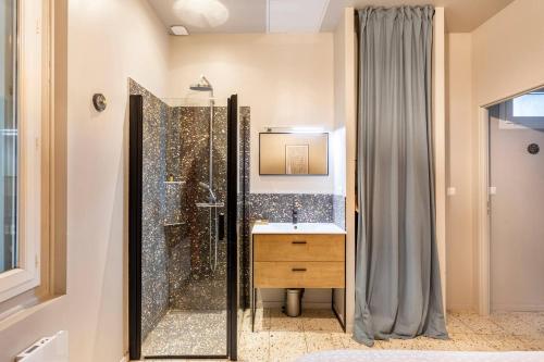 une salle de bain avec douche et lavabo dans l'établissement Revest, à Sète