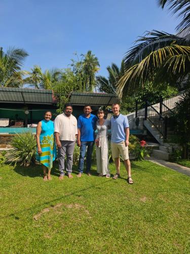 a group of people standing in the grass at Optimum Residencies in Negombo