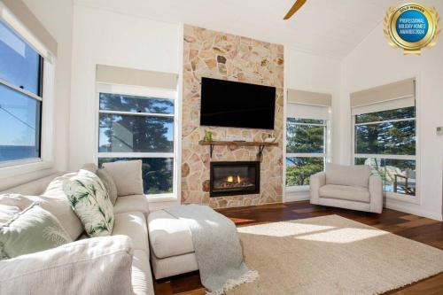 a living room with a couch and a fireplace at LegaSea Lodge - Pet Friendly Beachfront Plunge Pool in Shellharbour