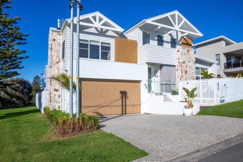 a white house with a garage in the driveway at LegaSea Lodge - Pet Friendly Beachfront Plunge Pool in Shellharbour