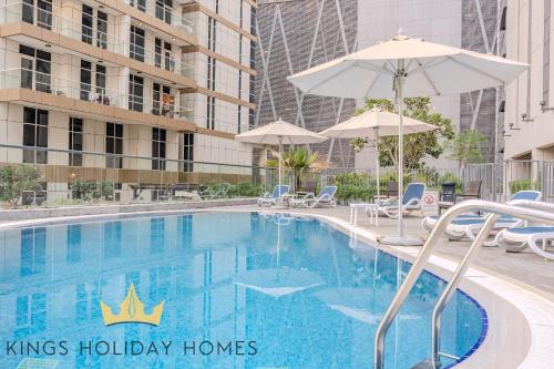 a large swimming pool with umbrellas next to a building at Luxury 2 Apartments Dunya tower Burj Khalifa St in Dubai