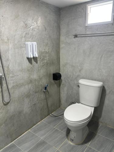 a bathroom with a toilet and a phone on the wall at The Bay Koh Mook in Trang