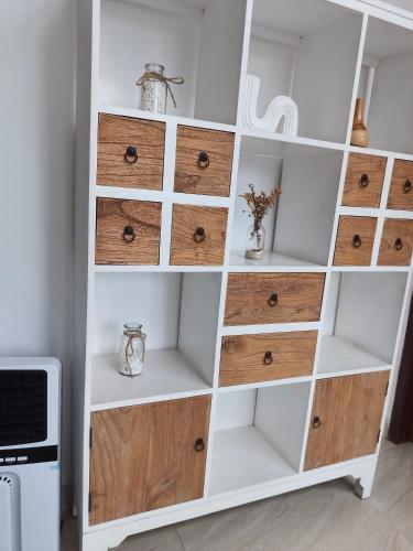 a white book shelf with wooden drawers at Aline Villa in Wonosobo