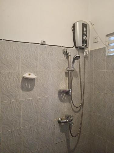 a shower in a bathroom with a shower head at Sobasee Holiday Bungalow in Kandy