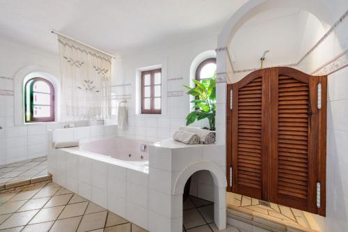 a white bathroom with a tub and a sink at Villa Can Mestre con vistas a la puesta de Sol in San Antonio Bay