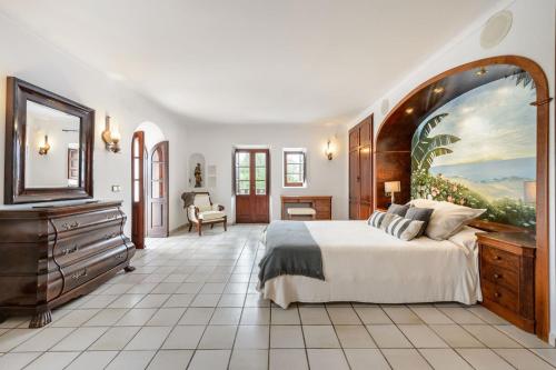 a bedroom with a large bed and a painting on the wall at Villa Can Mestre con vistas a la puesta de Sol in San Antonio Bay