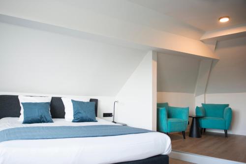 ブルージュにあるHuyze Lapin vakantiewoning Bruggeのベッドルーム1室(ベッド1台、青い椅子2脚付)