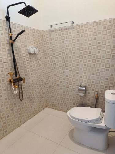 a bathroom with a toilet and a shower at Aline Villa in Wonosobo