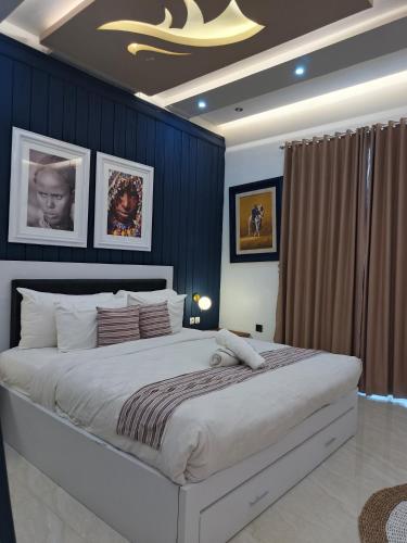 a bedroom with a large bed with blue walls at Aline Villa in Wonosobo