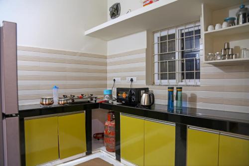 a kitchen with a yellow and black counter top at Delightful 3 Bed holiday home with AC Near US Embassy, Gachibowli in Hyderabad
