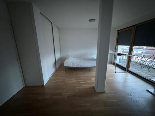 une chambre blanche avec un lit et une fenêtre dans l'établissement Studio Chablais Park, à Annemasse