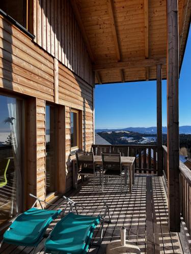 a wooden deck with a table and chairs on it at Almchalet Villa Diana in Klippitztorl