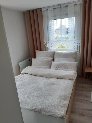 two beds in a small room with a window at Domek POD LASEM in Opole