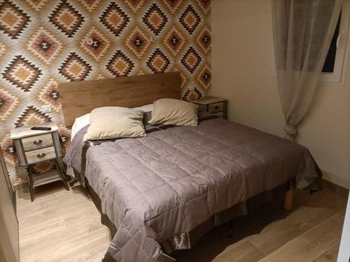 une chambre avec un lit avec une tête de lit en bois dans l'établissement Superbe appartement neuf au cœur de la Provence., à Entraigues-sur-la-Sorgue