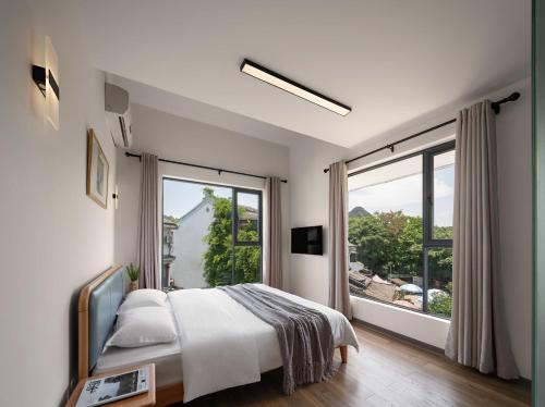 a bedroom with a bed and a large window at Castle peak yard Inn Free railway st ation pick-up by 2 nights English and Spanish reception available in Guilin