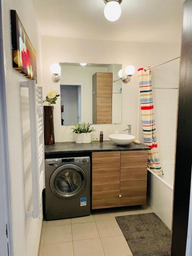 une salle de bain avec une machine à laver et un lavabo dans l'établissement T3 récent avec terrasse et parking, à Marseille