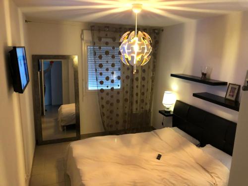 une chambre avec un lit et un grand miroir dans l'établissement T3 récent avec terrasse et parking, à Marseille