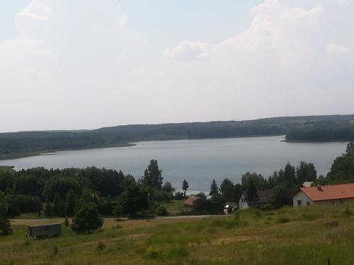 a view of a lake from a hill at Domki Rekreacyjne "Błękitne Wzgórze" in Żałe