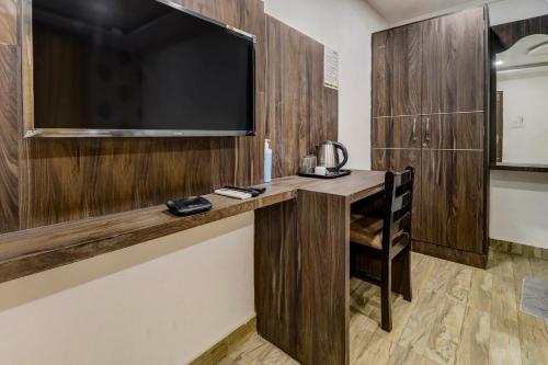 a room with a television and a table with a chair at Hotel Namo Again By IGI in New Delhi