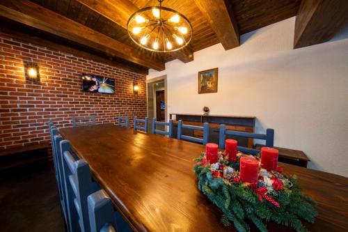 a dining room with a long wooden table with red candles at Mariska Villa in Izvoru Mureşului