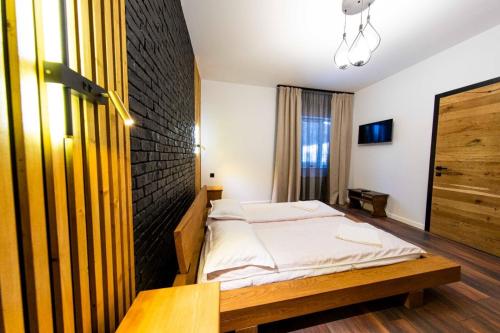 a bedroom with a bed and a wooden table at Mariska Villa in Izvoru Mureşului