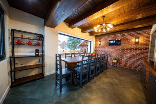 a dining room with a table and a brick wall at Mariska Villa in Izvoru Mureşului