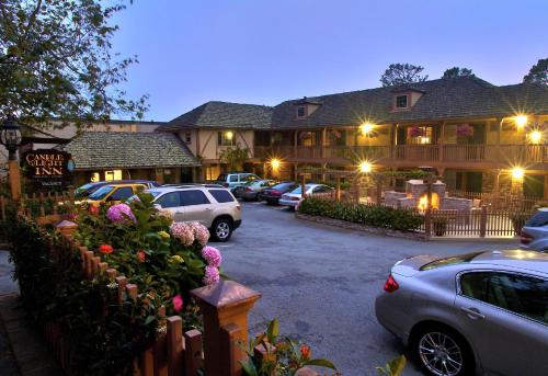 a parking lot with cars parked in front of a lodge at Candle Light Inn in Carmel