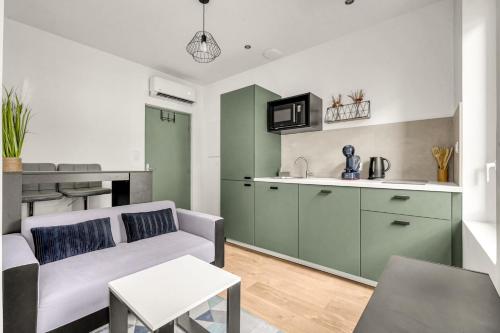un salon avec un canapé et une cuisine dans l'établissement Cosy appartement sur Toulouse, à Toulouse