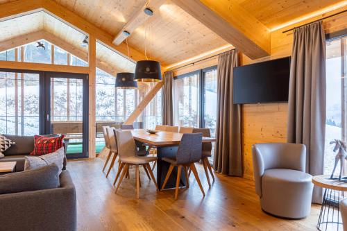 a dining room and living room with a table and chairs at Bergresort Hauser Kaibling by ALPS RESORTS in Haus im Ennstal