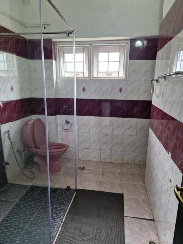 a bathroom with a shower with a toilet at Narmada Holiday Home in Ooty