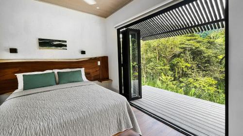 a bedroom with a bed and a large window at Casa Ker Lumar in Uvita