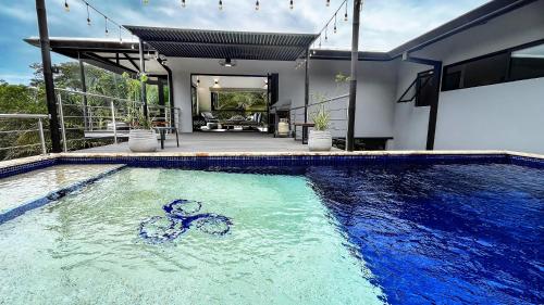 a swimming pool in front of a house at Casa Ker Lumar in Uvita