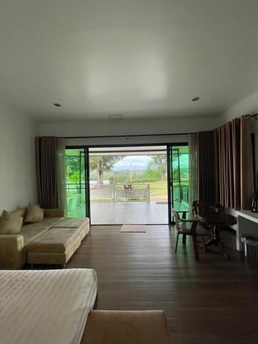 a bedroom with a bed and a couch and a table at River valley resort แอทน่าน in Nan