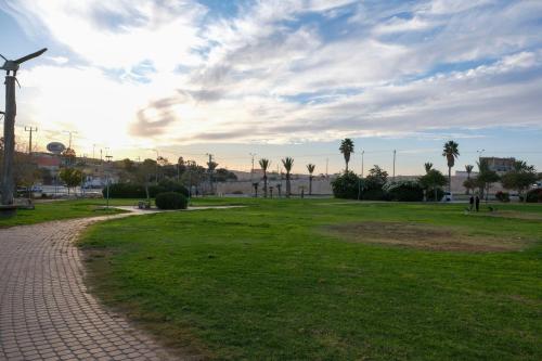 a park with palm trees and a windmill at צימר פלטינום - צימר עם בריכה וג'קוזי פרטיים בערד in Arad