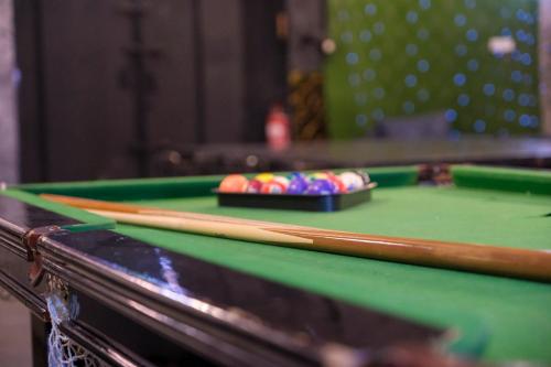 a pool table with two bats and balls on it at צימר פלטינום - צימר עם בריכה וג'קוזי פרטיים בערד in Arad