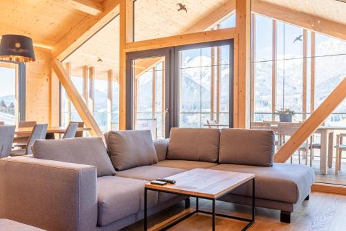 a living room with a couch and a table at Bergresort Hauser Kaibling by ALPS RESORTS in Haus im Ennstal