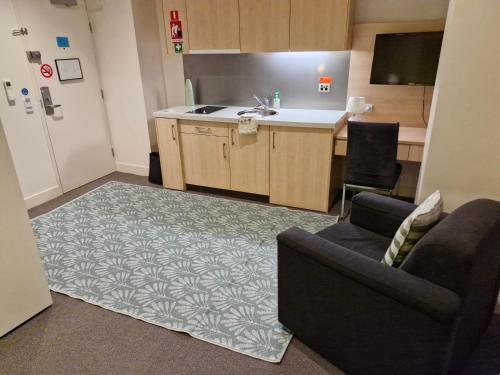 a living room with a couch and a kitchen at Cool City 1 Bedroom in Melbourne