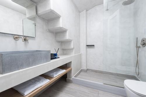 a white bathroom with a sink and a shower at Karat Suites in Vóthon