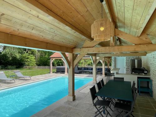 - un pavillon avec une piscine, une table et des chaises dans l'établissement Superbe villa refaite 2023 Climatisation piscine SPA, à Bourdonné