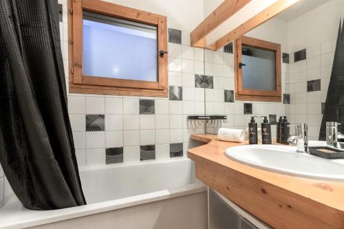 une salle de bain avec une baignoire, un lavabo et une douche dans l'établissement Jardin du Mont Blanc, à Chamonix-Mont-Blanc