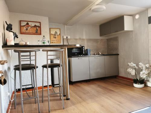 une cuisine avec un comptoir et des tabourets dans une pièce dans l'établissement Apparat, à Colmar