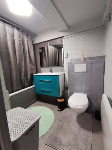 une salle de bain avec un lavabo bleu et des toilettes dans l'établissement Apparat, à Colmar