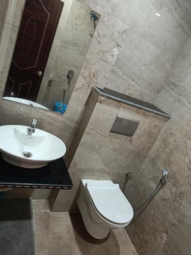 a bathroom with a white toilet and a sink at Pragya international in Varanasi